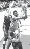  ?? Eric Christian Smith/AP ?? ■ Houston Rockets center Clint Capela (15) shoots as Dallas Mavericks guard Dennis Smith Jr., bottom, and forward Doug McDermott, left, defend during the first half of an NBA basketball game Sunday in Houston.