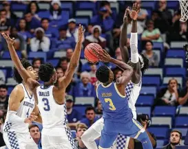  ?? Scott Threlkeld / Associated Press ?? Kentucky defenders Nick Richards, left, Hamidou Diallo, center, and Wenyen Gabriel could do little more than throw their hands into the air in an attempt to keep UCLA’s Aaron Holiday from scoring Saturday. Holiday had 20 points in helping lead the...