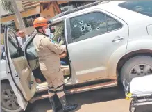  ??  ?? Un policía procede a sacar a la víctima del interior de la camioneta, que quedó con rastros de los disparos.