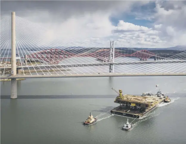  ??  ?? 0 The Iron Lady, with its cargo of a topside drilling platform for decommissi­oning, is towed by Forth Ports tugs at the Forth Bridges into the Port of Rosyth yesterday