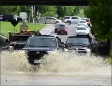  ?? ?? Vehicles drive underneath C-470on Acres Green Drive through deep water from a strong thundersto­rm and a reported tornado in the area Thursday.