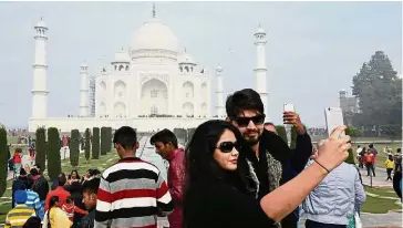  ?? — AFP ?? Must-see: Visitors taking a selfie in front of the Taj Mahal in Agra.