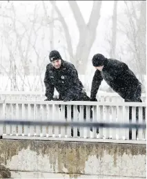  ?? JOHN MAHONEY ?? Police officers look down from a foot bridge over the Rivière des Prairies while searching for Ariel Jeffrey Kouakou.