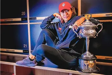  ?? FIONA HAMILTON/TENNIS AUSTRALIA VIA AP ?? Naomi Osaka poses with the Daphne Akhurst Memorial Cup in the locker room in the early hours Sunday after beating Jennifer Brady in the final of the Australian Open. It was Osaka’s second crown at Melbourne.