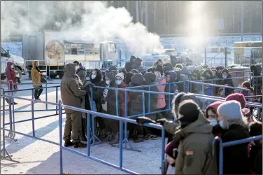  ?? ?? Migrants queue to receive hot food
Dec. 22 at the Bruzgi checkpoint logistics center.