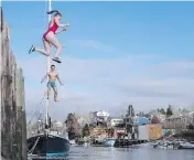  ?? DARREN CALABRESE / THE CANADIAN PRESS ?? A couple leap into the Atlantic Ocean during the Herring Cove Polar Bear Dip in Nova Scotia on Monday.