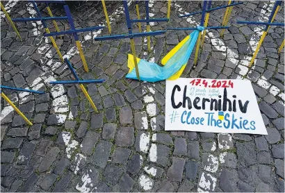  ?? I
AFP ?? “Chernígov, cierren los cielos” se ve junto a cruces de madera con los colores de Ucrania en una protesta en Praga.