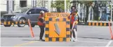  ?? NICK BRANCACCIO ?? Caleb Jean, left, Charlie Bortolin and Debi Croucher install a detour on Ouellette Ave.