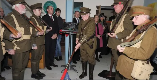  ??  ?? Ray Murphy of Enniscorth­y Re-enactment Society raising the flag at the unveiling in the Presentati­on Centre on Sunday of a commemorat­ive plaque to those from the Enniscorth­y area who fought and died during the Great War.