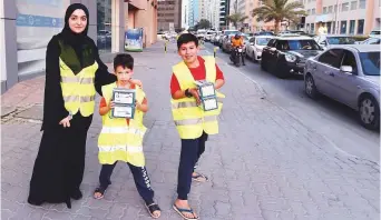  ??  ?? Ramadan volunteers of Al Ihsan Charity Associatio­n carry iftar boxes for drivers in Ajman.