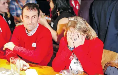  ?? JEFF MCINTOSH/THE CANADIAN PRESS ?? Members of Calgary’s “Yes” campaign react Tuesday to the results of a plebiscite on whether the city should proceed with a bid for the 2026 Winter Olympics. The plebiscite resulted in a 56-per-cent “No” against the bid.