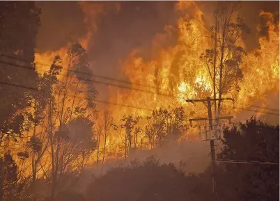  ?? — AFP ?? The Alisal Fire burns near power lines on Tuesday near Goleta, California. Pushed by high winds, the Alisal Fire grew overnight, shutting down the US 101 Freeway along the Pacific Coast.