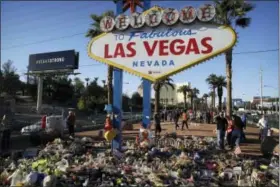  ?? JOHN LOCHER — THE ASSOCIATED PRESS ?? Flowers, candles and other items surround the famous Las Vegas sign at a makeshift memorial for victims of a mass shooting Monday in Las Vegas. Stephen Paddock opened fire on an outdoor country music concert killing dozens and injuring hundreds.