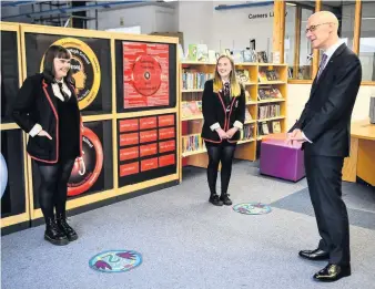  ??  ?? Achievemen­t
Deputy First Minister John Swinney chats to senior pupils at Stonelaw High yesterday