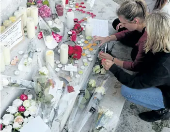  ?? FRANCOIS MORI/THE ASSOCIATED PRESS ?? Flowers, candles and messages are placed on the city hall entrance close to the home of Rev. Jacques Hamel after he was killed during an attack in a church in Saint-Etienne-du-Rouvray, Normandy, France. Two attackers invaded a church Tuesday during...