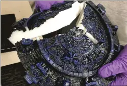  ??  ?? An agent holds a block of methamphet­amine disguised as an Aztec calendar seized in a raid. Nine members of an alleged Southern California drug traffickin­g ring are accused of shipping the contraband to Hawaii.