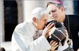  ?? FRANCO ORIGLIA/GETTY PHOTO ?? Pope Benedict XVI kisses a child lifted up by personal secretary Georg Ganswein as he leaves St. Peter’s Square on Wednesday. Benedict is retiring after eight years as pontiff.