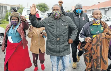  ?? Picture: Esa Alexander ?? Khayelitsh­a resident Bulelani Qolani, centre, and supporters at Harare police station, where he opened a case against the City of Cape Town after he was dragged out of his shack, naked, by city officials on Wednesday.