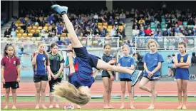  ??  ?? Scarlett Gillanders (9), of Abbotsford School, fills in time by doing an ‘‘aerial’’ while waiting for her turn at the long jump.