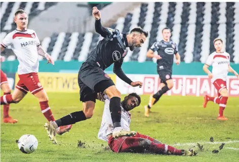  ??  ?? Pokalschla­cht: Düsseldorf­s Kenan Karaman (M.) kämpft mit Essens Daniel Heber (unten) um den Ball.