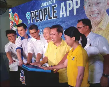  ??  ?? Dr Sim (third right) symbolical­ly launches the IPeople App while Chan (fourth left) and BN candidate for Bandar Kuching Kho Teck Wan (right) and others look on.