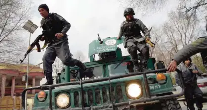  ??  ?? KABUL: Afghan policemen leap from a vehicle as they arrive at the site of an explosion. — AFP