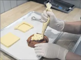  ?? ERIC RISBERG — THE ASSOCIATED PRESS ?? Pastry chef Elaine Lau creates a corn cheese croissant at the Sunday Bakeshop. AsianAmeri­can bakeries have donated money to organizati­ons fighting hate against Asians.