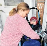  ?? ROSIE MULLALEY • THE TELEGRAM ?? Adina Stamp gets her five-year-old son, Lyndon, situated in a specialize­d wheelchair in front of their Bay Bulls home before heading out for a hike earlier this week. The specialize­d wheelchair was borrowed from the Janeway children’s hospital, but Stamp hopes the family can someday have one of their own.