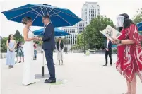  ?? JONATHAN HAYWARD THE CANADIAN PRESS ?? Wedding commission­er Ruth Lipton officiates the marriage of Nikki Alexis and Roni Jones at Vancouver city hall on Friday.