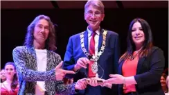  ?? Picture: Reading Borough Council ?? Alun, left, and Selina, right, collecting their trophy from the mayor, centre.