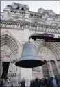  ?? The Associated Press ?? A new bell is raised from a flatbed truck in front of the Notre Dame cathedral in
Paris on Thursday.