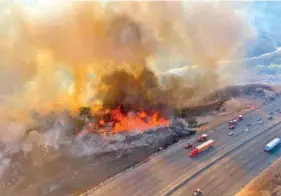  ?? LOS ANGELES COUNTY FIRE AIR OPERATIONS VIA AP ?? In this aerial photo, traffic passes the Route fire, a brush wildfire off Interstate 5 north of Castaic, Calif., on Saturday.