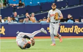  ?? STEVE NESIUS/AP ?? Orioles left fielder Anthony Santander, right, watches as third baseman Ramón Urías tumbles after catching a pop fly in the eighth inning Sunday in St. Petersburg, Florida.
