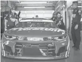  ?? JARED C. TILTON/GETTY ?? Crew members push the #5 Chevrolet, driven by Kyle Larson, out of the garage Friday. The NASCAR Cup finale is Sunday at Phoenix Raceway.