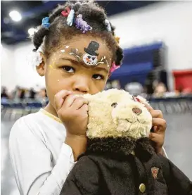  ?? Jon Shapley / Houston Chronicle ?? Nikia McKnight, 3, picked up a new teddy bear at the Christmas Eve Big Feast on Saturday at the George R. Brown Convention Center.