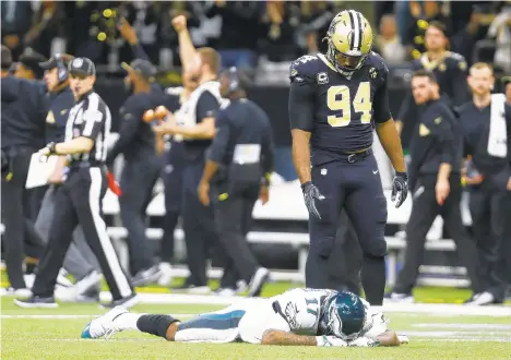  ?? BUTCH DILL/AP ?? Eagles wide receiver Alshon Jeffery (17) lies on the turf in front of Saints defensive end Cameron Jordan (94) after the Saints intercepte­d a pass that went through Jeffery’s hands in the closing minutes of Sunday’s NFC divisional playoff game in New Orleans.