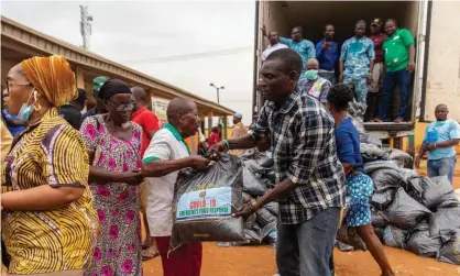  ??  ?? Lagos state officials hand out food relief bags as Nigeria tries to curb the spread of the coronaviru­s. Photograph: Ibeabuchi Benson Ugochukwu/AFP via Getty Images