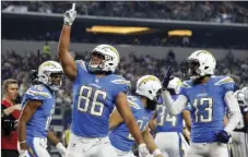  ??  ?? Los Angeles Chargers’ Hunter Henry (86) celebrates his touchdown catch with Tyrell Williams (16) and Keenan Allen (13) in the second half of an NFL football game against the Dallas Cowboys on Thursday in Arlington, Texas. AP PHOTO/MICHAEL AINSWORTH