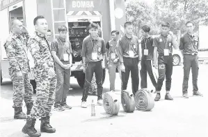  ??  ?? AHLI KRS bersedia melakukan aktiviti kemahiran mengendali­kan hos bomba sambil dibimbing anggota bomba Sandakan (kiri).