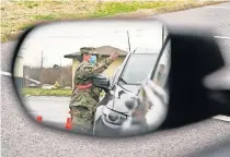  ??  ?? A National Guard soldier directing drivers is reflected in the mirror of a car waiting in a COVID-19 vaccinatio­n line Friday in Shelbyvill­e, Tenn. [MARK HUMPHREY/ THE ASSOCIATED PRESS]