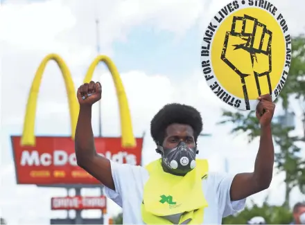  ?? PAUL SANCYA/AP ?? Jerry Johnson takes part in a demonstrat­ion demanding improvemen­t of Black Americans’ experience­s in the workplace outside a Mcdonald’s in Detroit on Monday.