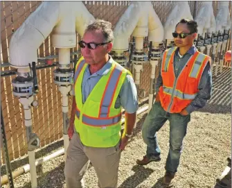  ?? Signal file photo ?? Operations Manger Hassan Amini, left, leads a tour of a soil vapor extraction treatment facility during a tour to view cleanup efforts of the Whittaker-Bermite site in Valencia in October 2016. Officials say that they are on schedule and that they...