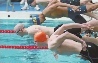  ?? STAFF PHOTO BY MATT WEST ?? A HEAD START: Wayland’s Sean Devlin leads off the platform, ahead of teammate Asa Greenaway (orange cap), in the 50-yard freestyle at yesterday’s Div. 2 state meet.