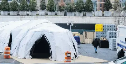  ?? PHOTO: NEW YORK DAILY NEWS/TNS ?? Grim task . . . Workers build a makeshift morgue outside Bellevue Hospital in Manhattan to deal with a potential surge of coronaviru­s victims.