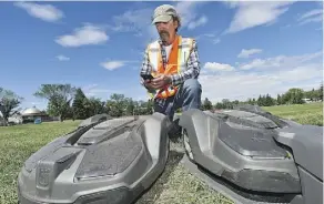  ?? ED KAISER ?? City turf team member Maurice Pelletier uses his phone to send commands to Edmonton’s first electric driverless lawn mowers.