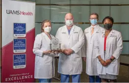  ?? Submitted photo ?? ■ From left, Dr. Erika Petersen, neurosurge­on, Dr. John Day, neurosurge­on and chair of the UAMS Department of Neurosurge­ry, Dr. Viktoras Palys, neurosurge­on, and Ebonye Green, APRN, Department of Neurosurge­ry, are shown with the award in this undated handout photo. Not pictured is Dr. Analiz Rodriguez, neurosurge­on.