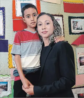  ?? MICHAEL DWYER THE ASSOCIATED PRESS ?? A Brazilian mother, who asked to be identified only as W.R. poses with her 9 year-old son A.R. after speaking during a news conference at the Brazilian Worker Center in Boston, Monday.