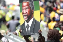  ??  ?? A party supporter holds up a poster of former president Thabo Mbeki, who – despite not being present – was honoured at the stadium yesterday.