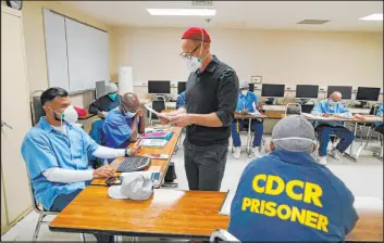  ?? Eric Risberg The Associated Press file ?? Instructor Douglas Arnwine returns papers with comments to his incarcerat­ed students during an English class at San Quentin State Prison in April 2022.