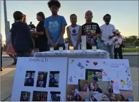  ?? MEDIANEWS GROUP FILE PHOTO ?? At center, from left, Aiden Coles, 11, Coney Brown, 11, and Staten Brown, 12, with the picture boards they brought to the prayer service in memory of their friends who died.